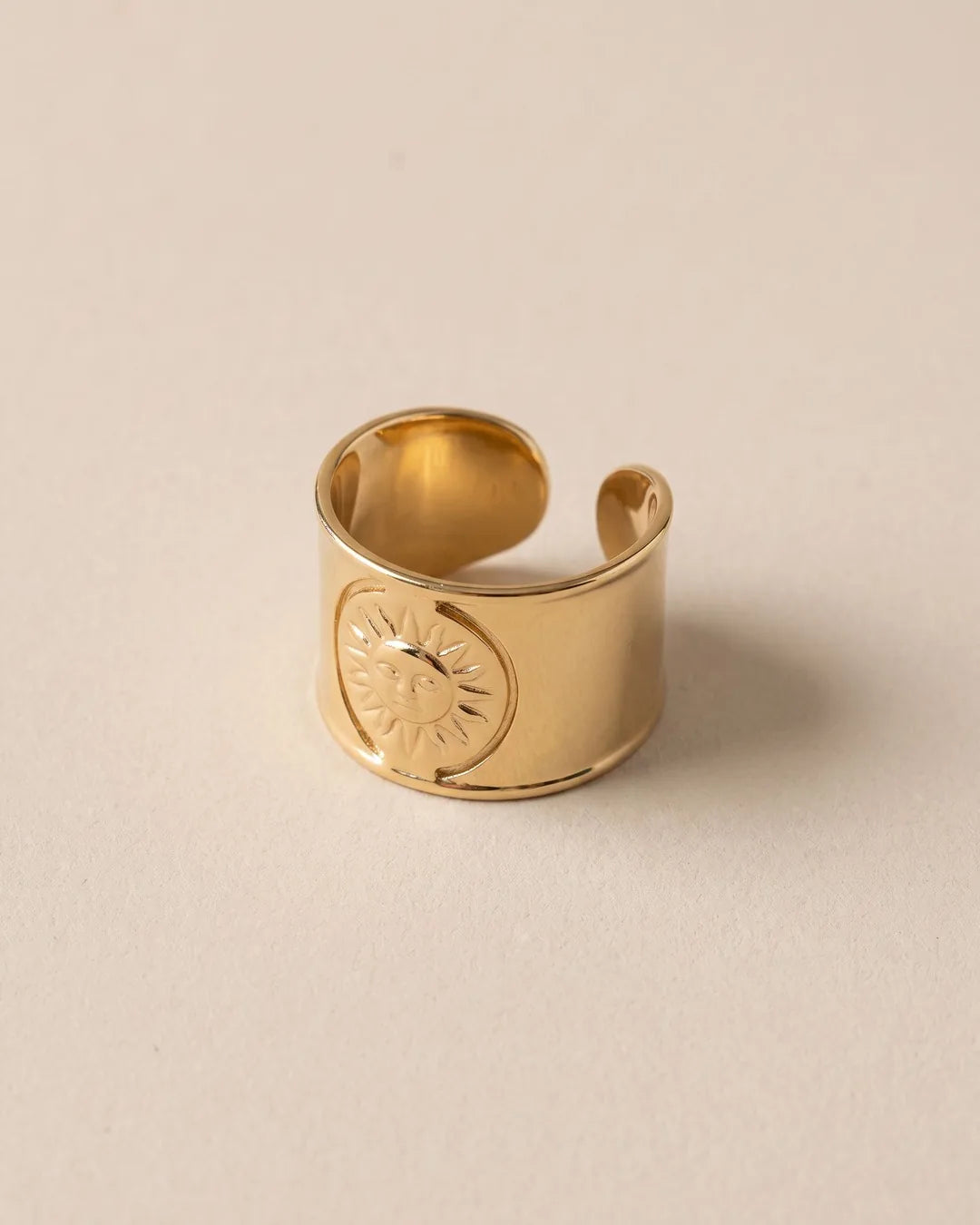 Bague Large Soleil Gravé Dorée, packshot sur fond beige