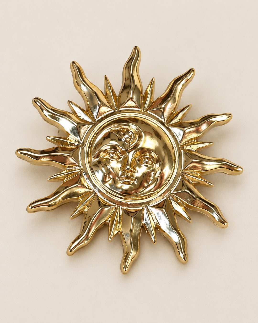 Broche Soleil Visage Doré, packshot sur fond beige