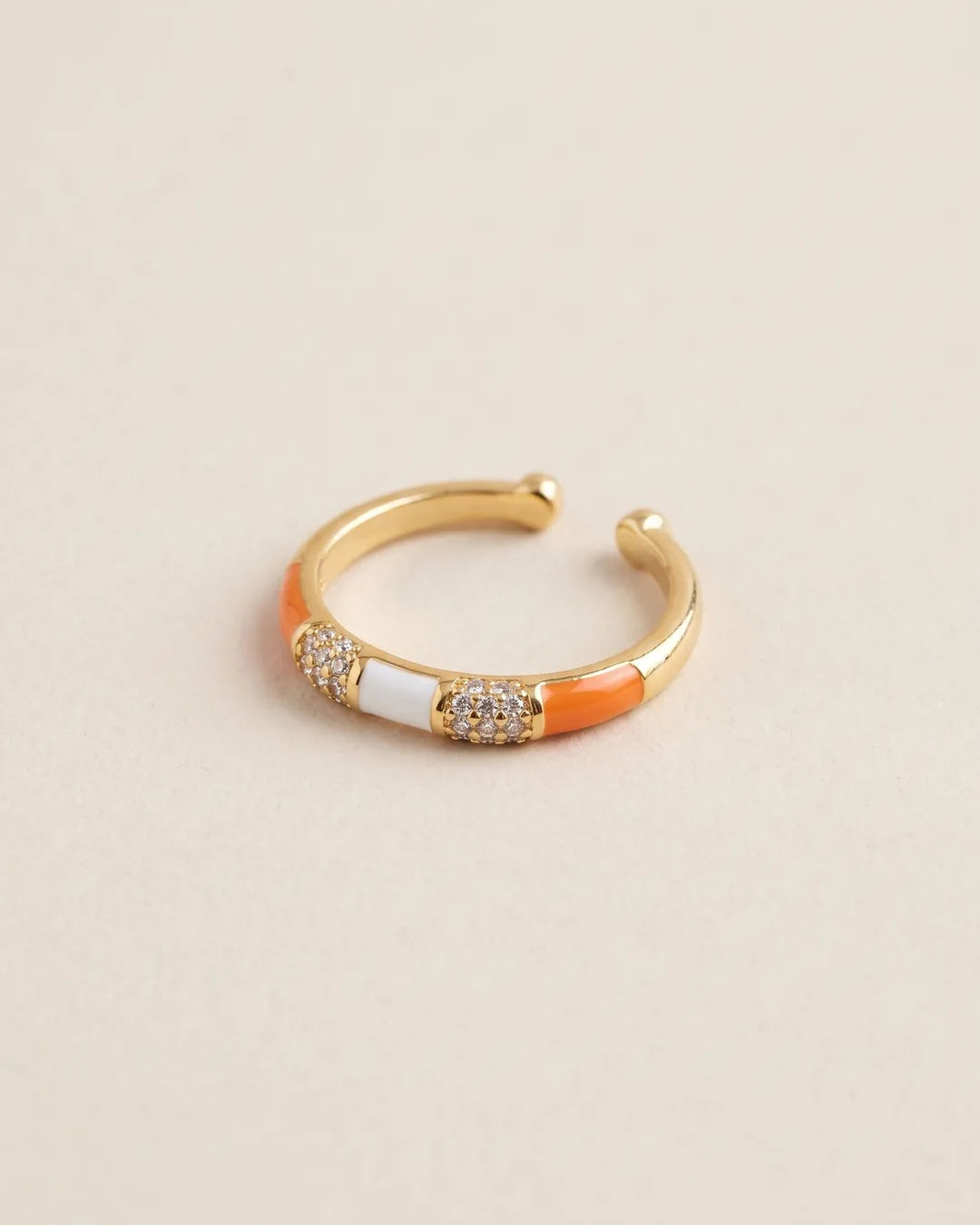 Bague Fine Émail Orange Blanc Cristaux Dorée, packshot sur fond beige