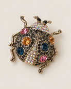 Broche Coccinelle Strass, packshot sur fond beige