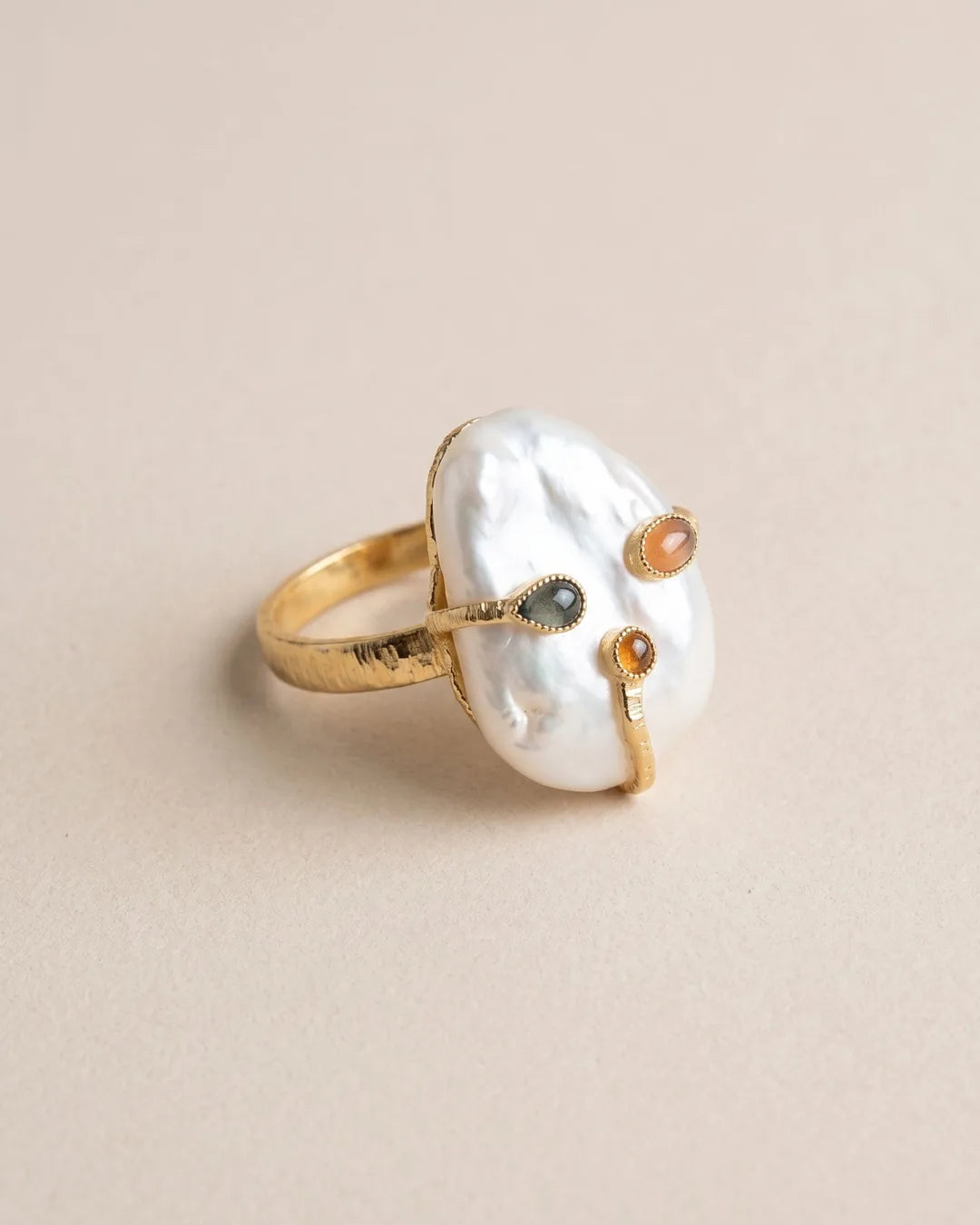 Bague Grande Perle Baroque Cabochons Dorée, packshot sur fond beige