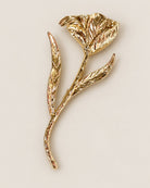 Broche Fleur Tige Dorée, packshot sur fond beige