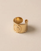 Bague Large Soleil Gravé Dorée, packshot sur fond beige