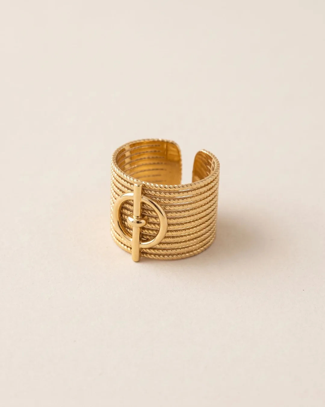 Bague Large Stries Boucle Dorée, packshot sur fond beige