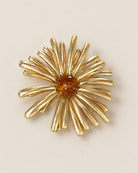 Broche Fleur Rayons Dorée, packshot sur fond beige