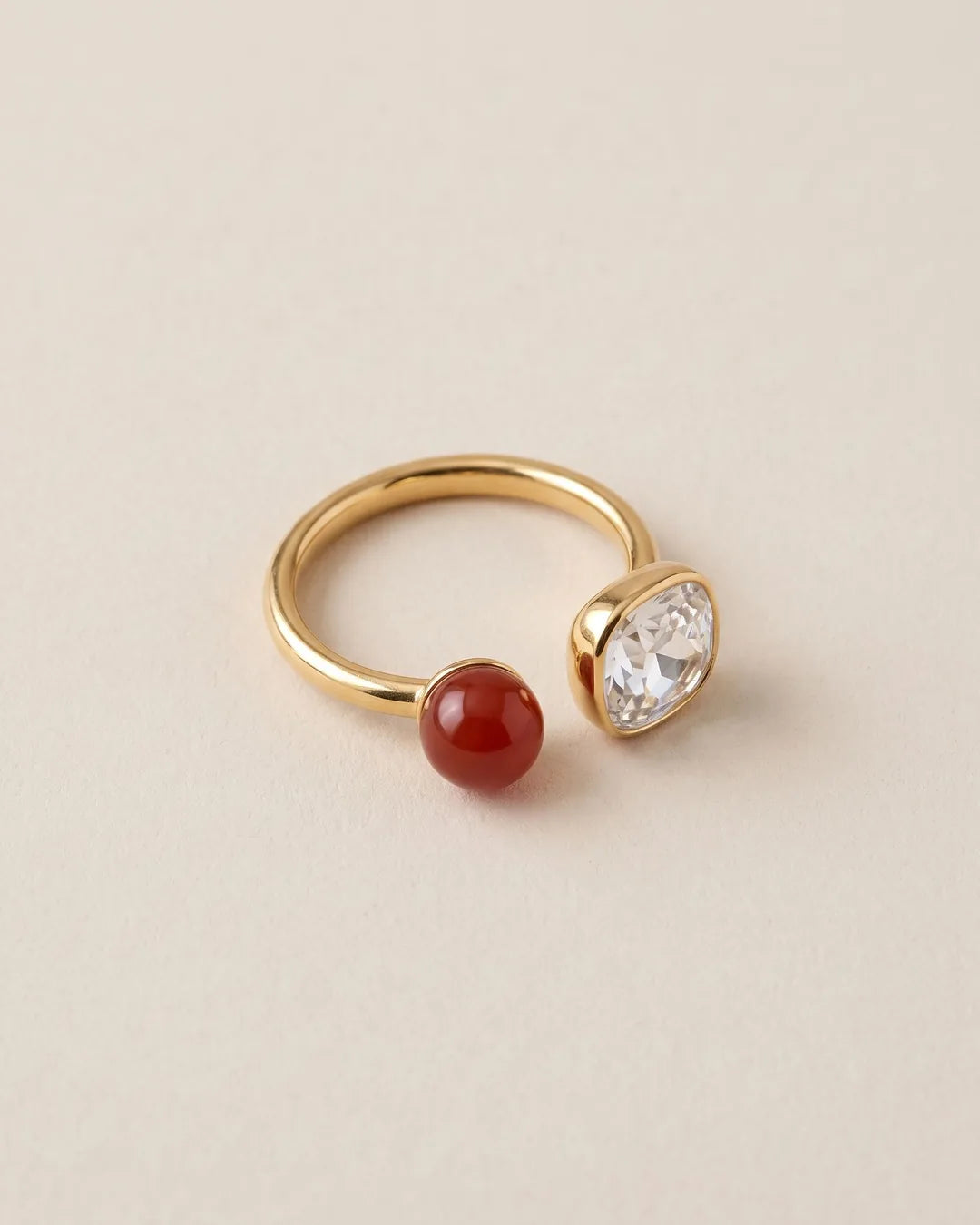 Bague Toi et Moi Pierre Rouge Dorée, packshot sur fond beige
