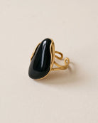 Bague Grand Cabochon Noir Dorée, packshot sur fond beige